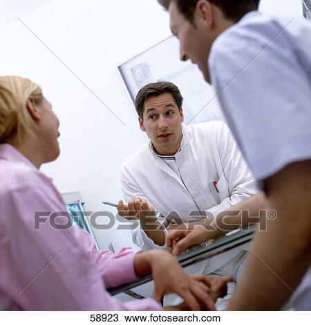 Male doctor advising young couple View Large Photo Image Stock Image - Male doctor advising young couple . Fotosearch