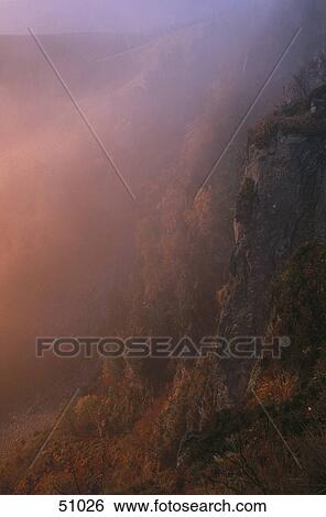 Stock Photograph - Misty mountains at sunrise, Vosges, France . Fotosearch