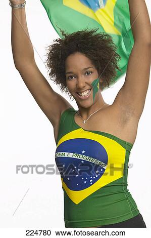 Portrait of female soccer fan holding Brazilian flag and smiling View Large Photo Image Stock Image - Portrait of female soccer fan holding Brazilian flag and smiling . Fotosearch