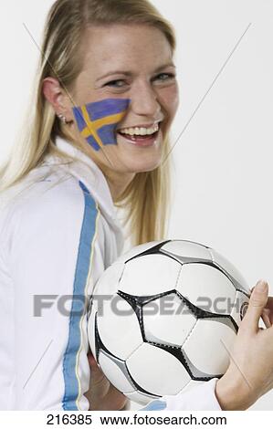 Portrait of female soccer fan holding soccer ball and smiling View Large Photo Image Stock Photography - Portrait of female soccer fan holding soccer ball and smiling . Fotosearch