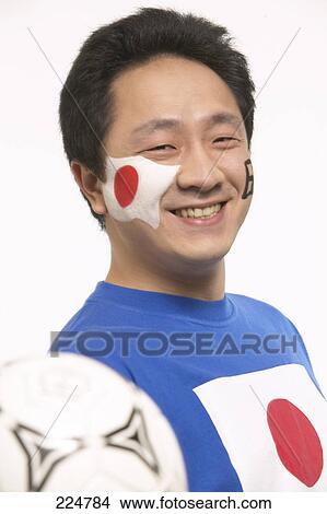 Picture - Portrait of male soccer fan holding soccer ball and smiling . Fotosearch