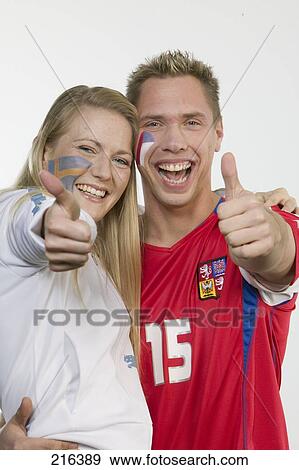 Stock Photo - Portrait of two soccer fans showing thumbs up and smiling . Fotosearch