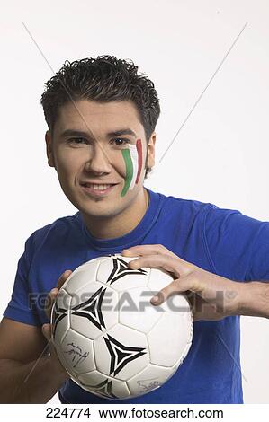 Portrait of young man holding soccer ball and smiling View Large Photo Image Picture - Portrait of young man holding soccer ball and smiling . Fotosearch
