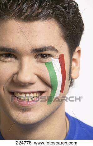 Stock Photograph - Portrait of young man with Italian painted flag on his face . Fotosearch