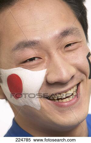 Stock Photography - Portrait of young man with japanese painted flag on his face . Fotosearch