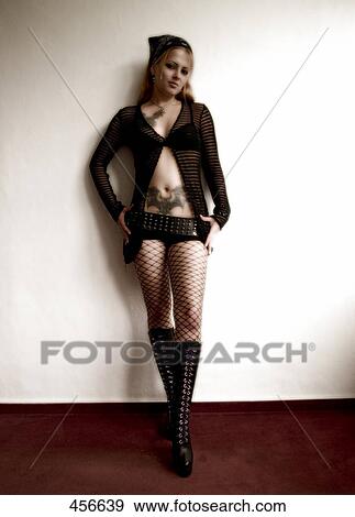 Stock Photo - Portrait of young woman leaning against wall . Fotosearch