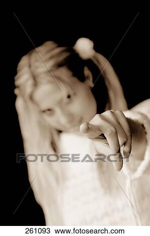 Stock Image - Portrait of young woman pointing . Fotosearch