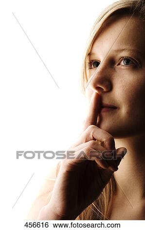 Portrait of young woman with her finger on her lips View Large Photo Image Stock Photograph - Portrait of young woman with her finger on her lips . Fotosearch