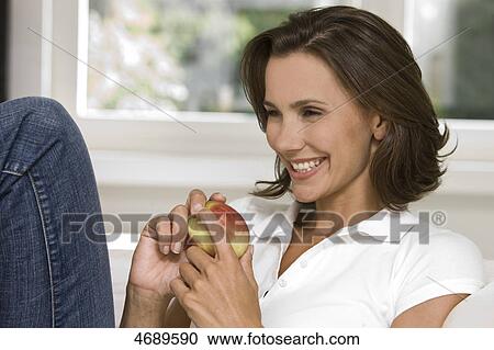 Smiling woman holding an apple View Large Photo Image Stock Image - Smiling woman holding an apple . Fotosearch