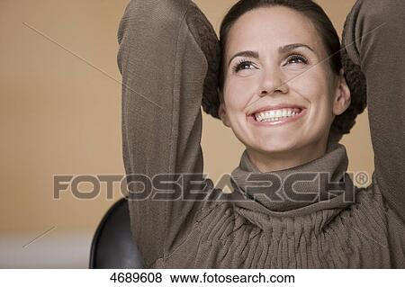 Stock Photo - Smiling woman wearing brown pullover . Fotosearch