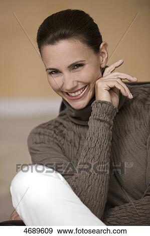 Stock Photo - Smiling woman wearing brown pullover . Fotosearch
