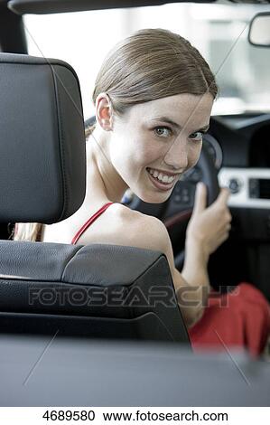 Smiling young woman in a car  View Large Photo Image Stock Image - Smiling young woman in a car . Fotosearch