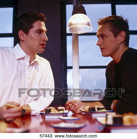 Stock Image - Two businessmen eating sushi . Fotosearch