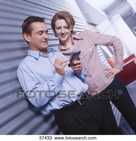 Two businesspeople looking at personal organizer View Large Photo Image Stock Image - Two businesspeople looking at personal organizer . Fotosearch