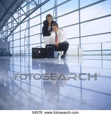 Two businesspeople with laptop, low angle view View Large Photo Image Stock Photograph - Two businesspeople with laptop, low angle view . Fotosearch