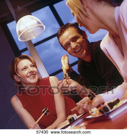 Two businesswomen and businessman eating sushi in bar View Large Photo Image Stock Image - Two businesswomen and businessman eating sushi in bar . Fotosearch