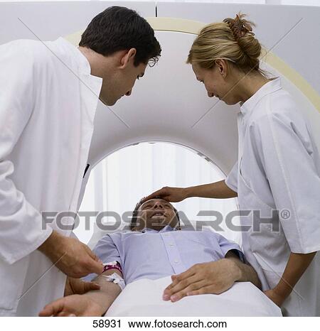 Two doctors examining patient on MRI scanbed View Large Photo Image Stock Image - Two doctors examining patient on MRI scanbed . Fotosearch