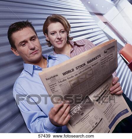 Two employees reading a newspaper View Large Photo Image Stock Photo - Two employees reading a newspaper . Fotosearch