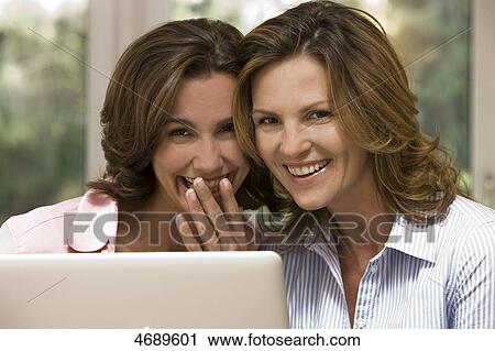 Two happy women using laptop View Large Photo Image Stock Image - Two happy women using laptop . Fotosearch
