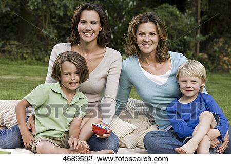Two happy women with two children on blanket outdoors View Large Photo Image Stock Image - Two happy women with two children on blanket outdoors . Fotosearch