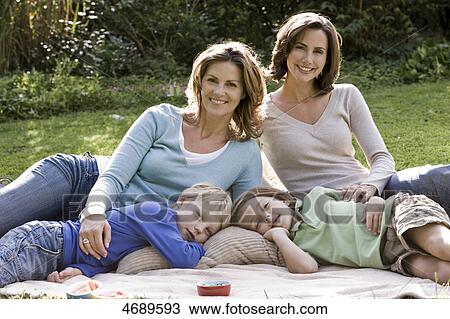 Two happy women with two children on blanket outdoors View Large Photo Image Stock Image - Two happy women with two children on blanket outdoors . Fotosearch
