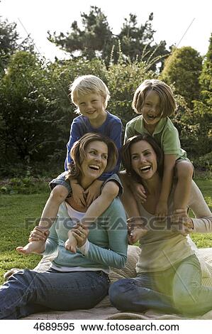 Two happy women with two children on blanket outdoors View Large Photo Image Stock Photography - Two happy women with two children on blanket outdoors . Fotosearch