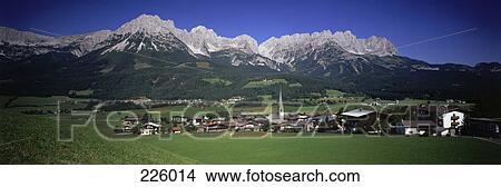 Picture - Village on grassy landscape with mountains in background, Ellmau, Tyrol, Austria . Fotosearch