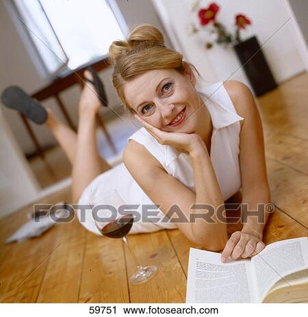 Woman lying on floor and reading a book, elevated view View Large Photo Image Stock Image - Woman lying on floor and reading a book, elevated view . Fotosearch