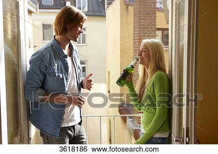 Young couple drinking beer on balcony View Large Photo Image Stock Photograph - Young couple drinking beer on balcony . Fotosearch