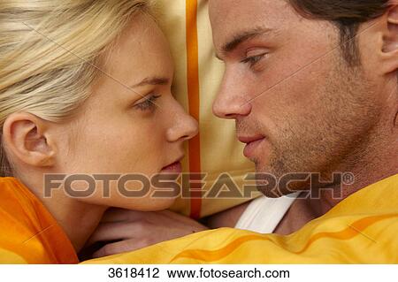 Young couple in bed looking at each other View Large Photo Image Stock Image - Young couple in bed looking at each other . Fotosearch