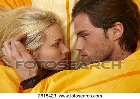 Young couple in bed looking at each other View Large Photo Image Stock Image - Young couple in bed looking at each other . Fotosearch