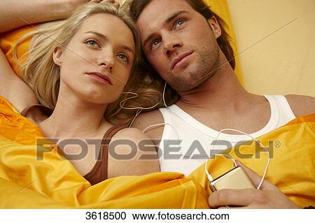 Young couple in bed with mp3 player View Large Photo Image Stock Image - Young couple in bed with mp3 player . Fotosearch