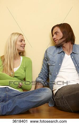 Young couple sitting on floor smiling View Large Photo Image Stock Image - Young couple sitting on floor smiling . Fotosearch