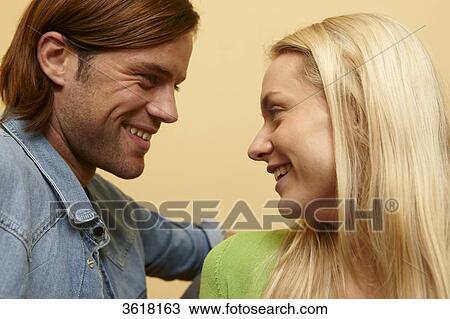 Young couple smiling at each other View Large Photo Image Stock Image - Young couple smiling at each other . Fotosearch