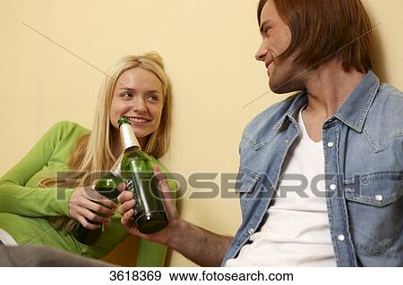 Young couple toasting with beer bottles View Large Photo Image Stock Photo - Young couple toasting with beer bottles . Fotosearch