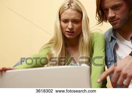 Young couple using laptop View Large Photo Image Stock Image - Young couple using laptop . Fotosearch