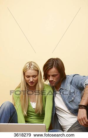Stock Photo - Young couple using laptop . Fotosearch