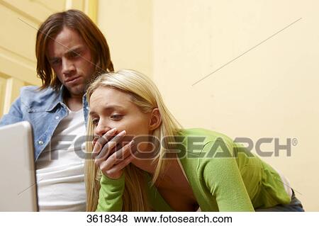 Stock Photo - Young couple using laptop . Fotosearch
