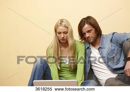 Young couple using laptop View Large Photo Image Stock Photography - Young couple using laptop . Fotosearch