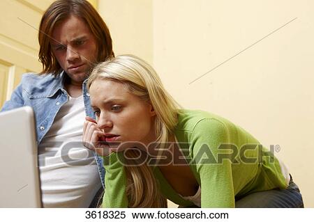 Young couple using laptop View Large Photo Image Stock Photography - Young couple using laptop . Fotosearch