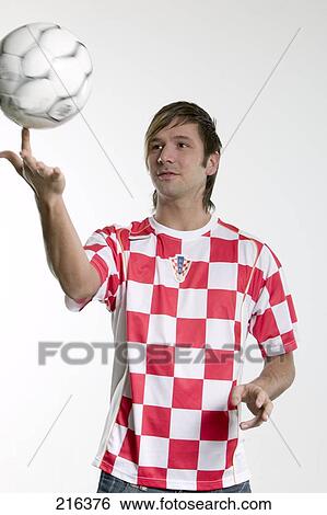 Young man balancing soccer ball on his finger View Large Photo Image Stock Photograph - Young man balancing soccer ball on his finger . Fotosearch
