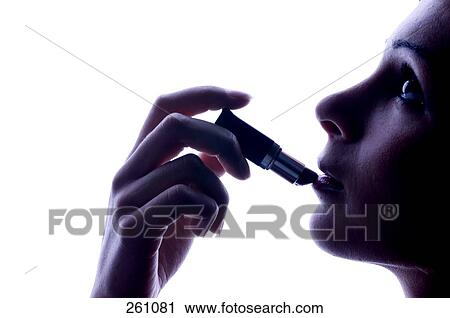 Young woman applying lipstick on lips, side view View Large Photo Image Stock Image - Young woman applying lipstick on lips, side view . Fotosearch