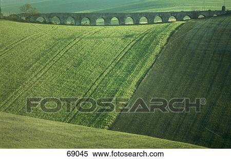 Stock Photography - Ancient aqueduct on cultivated landscape, Tranquinia, Tuscany, Italy . Fotosearch
