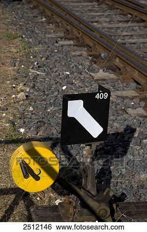 Stock Photograph - Arrow sign besides railroad track . Fotosearch