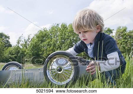 Picture - Blond boy playing outside . Fotosearch