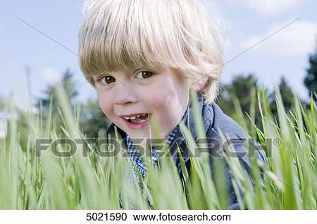 Stock Image - Blond boy playing outside . Fotosearch