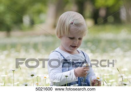 Blond girl on a flower meadow View Large Photo Image Stock Image - Blond girl on a flower meadow . Fotosearch