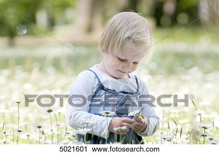 Blond girl on a flower meadow View Large Photo Image Stock Image - Blond girl on a flower meadow . Fotosearch