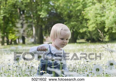 Blond girl on a flower meadow View Large Photo Image Stock Image - Blond girl on a flower meadow . Fotosearch