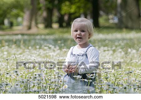 Blond girl on a flower meadow View Large Photo Image Stock Photo - Blond girl on a flower meadow . Fotosearch